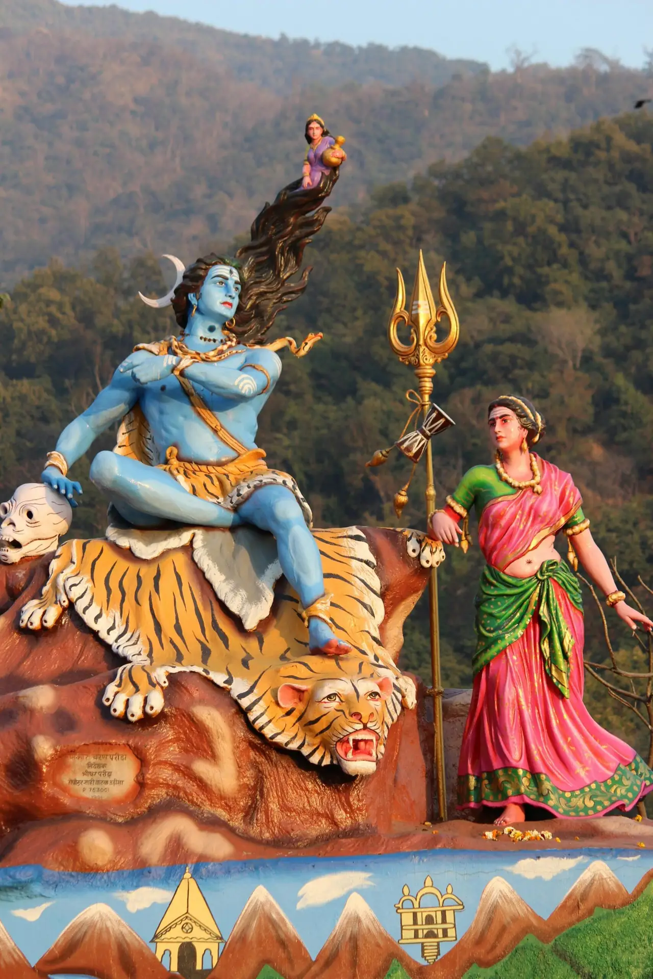 Vibrant statues of Hindu gods Shiva and Parvati in Rishikesh, India, set against a scenic backdrop.